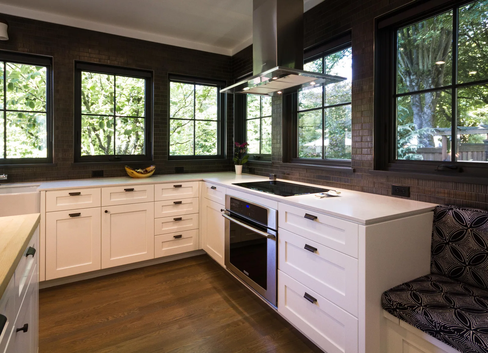 White painted kitchen cabinets under black-framed windows