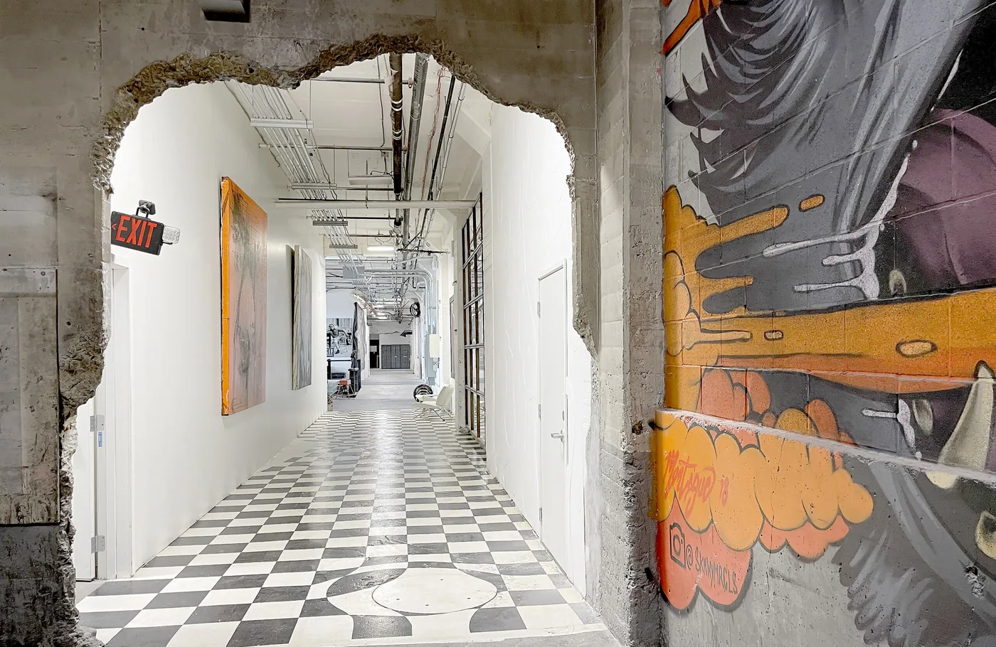 Bright commercial corridor with a checker floor and a painted mural