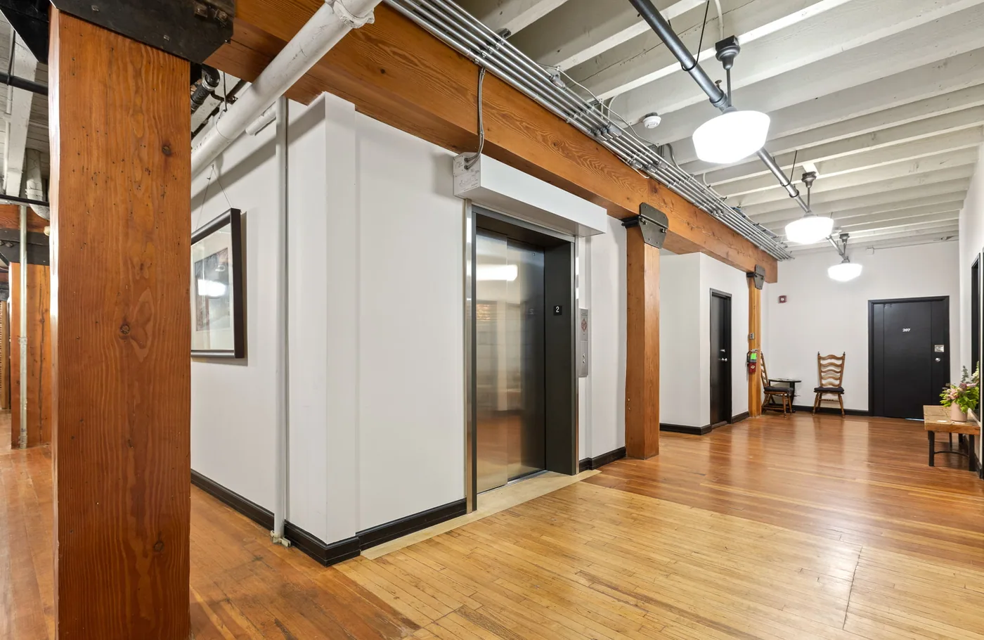 Commercial corridor with painted walls, timber posts and a painted ceiling