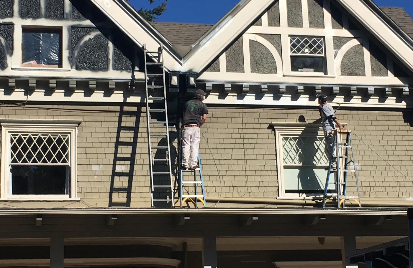 White gable trim and bracket detail on a dark Portland Victorian