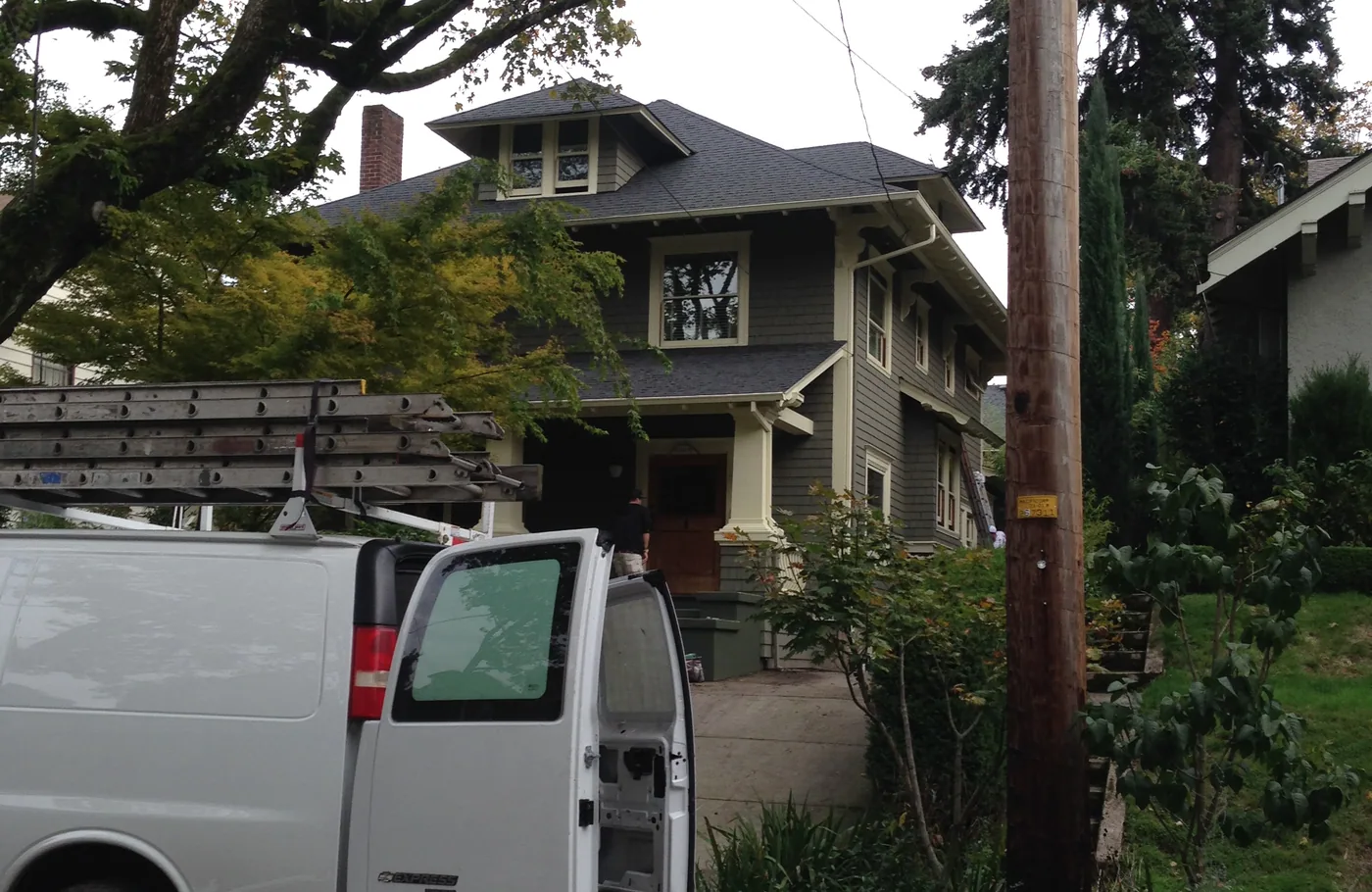 Work van and ladders outside a Portland craftsman during an exterior repaint