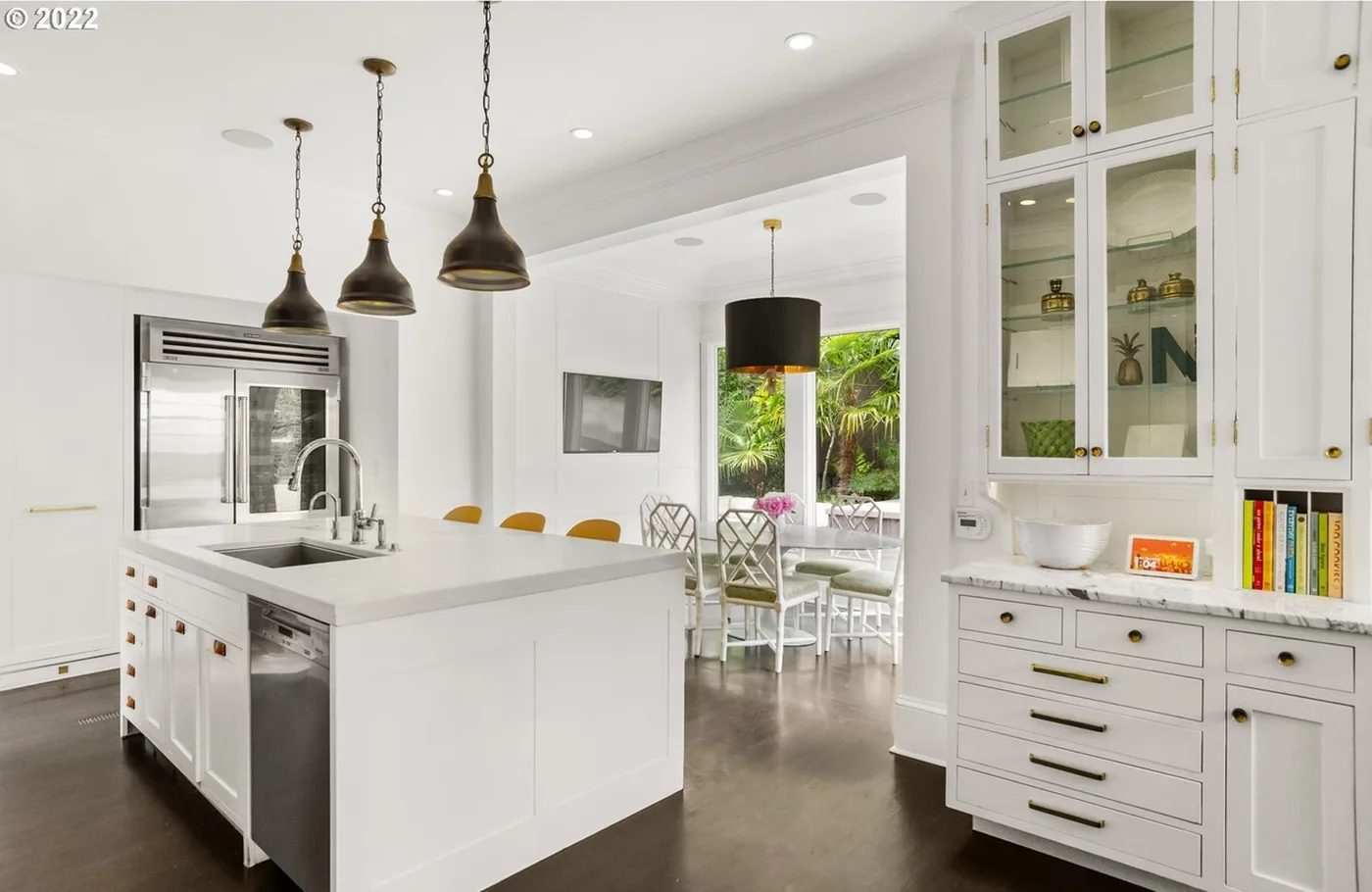 Painted island and glass-front cabinets beside the dining area