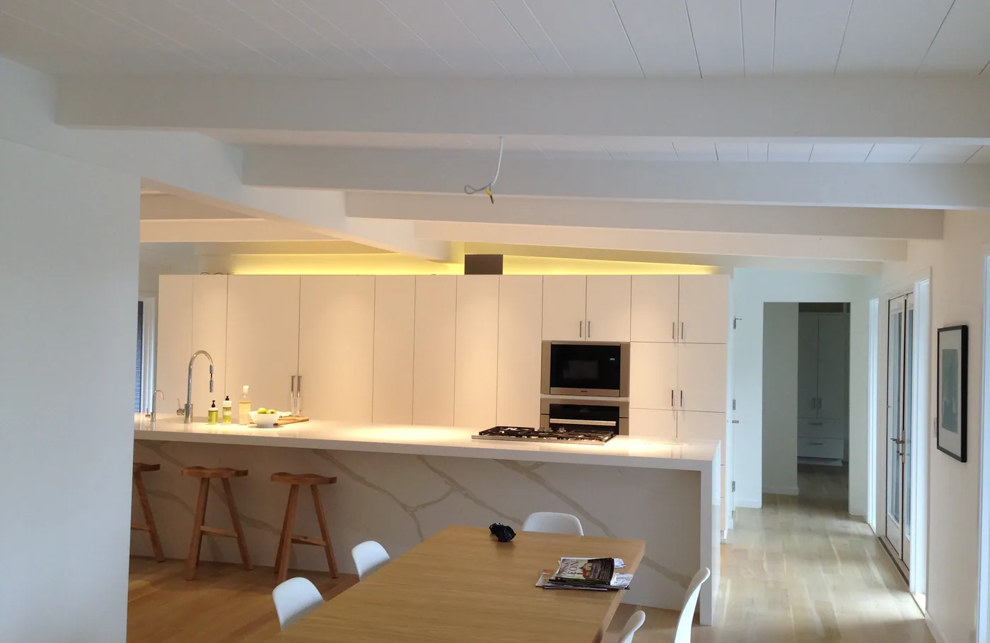 White flat-panel kitchen with under-cabinet lighting