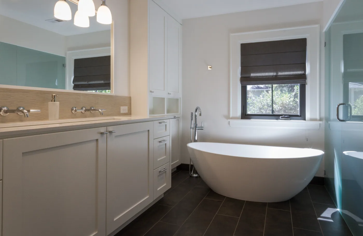 White bathroom vanity beside a freestanding tub