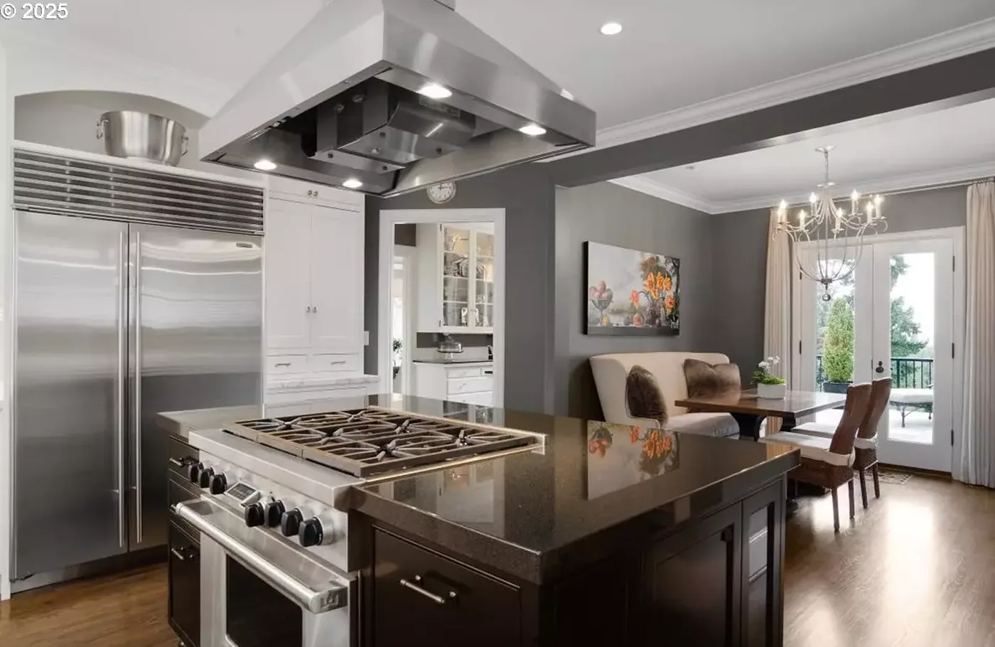 Kitchen with dark island and white cabinetry