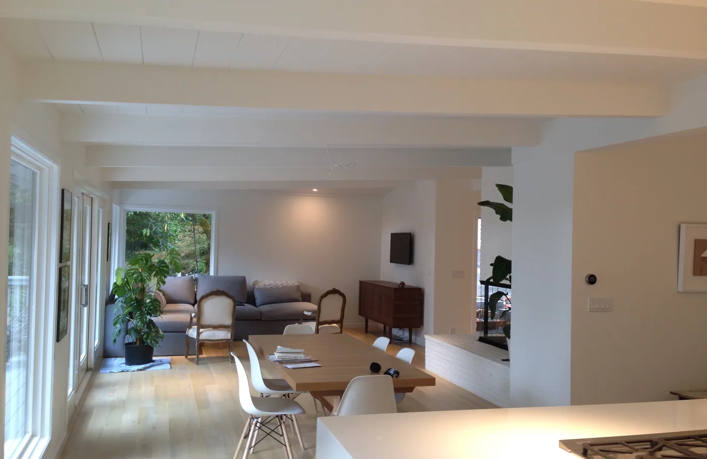 Bright open living room with a white beamed ceiling