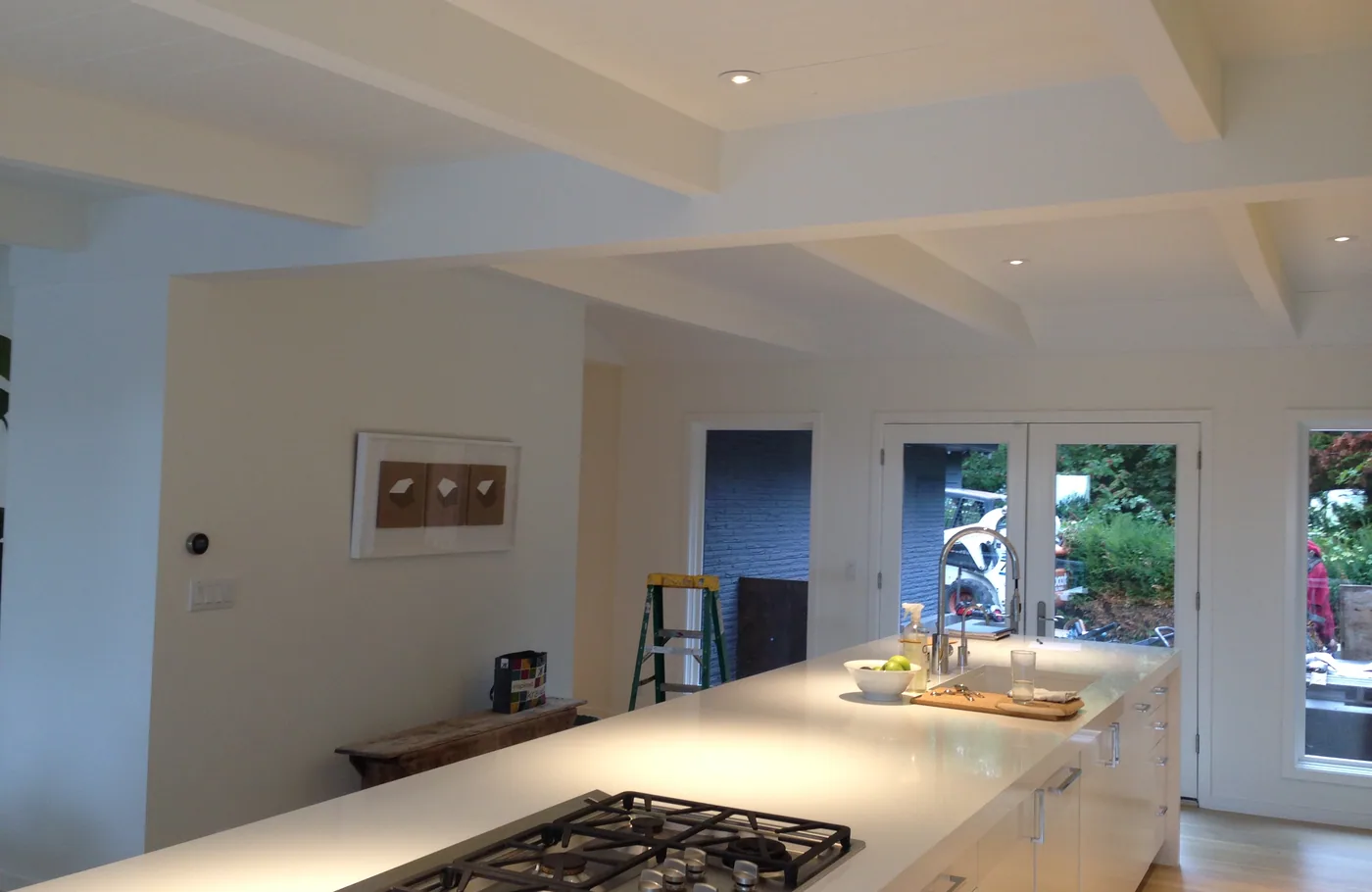 White kitchen under a painted beamed ceiling