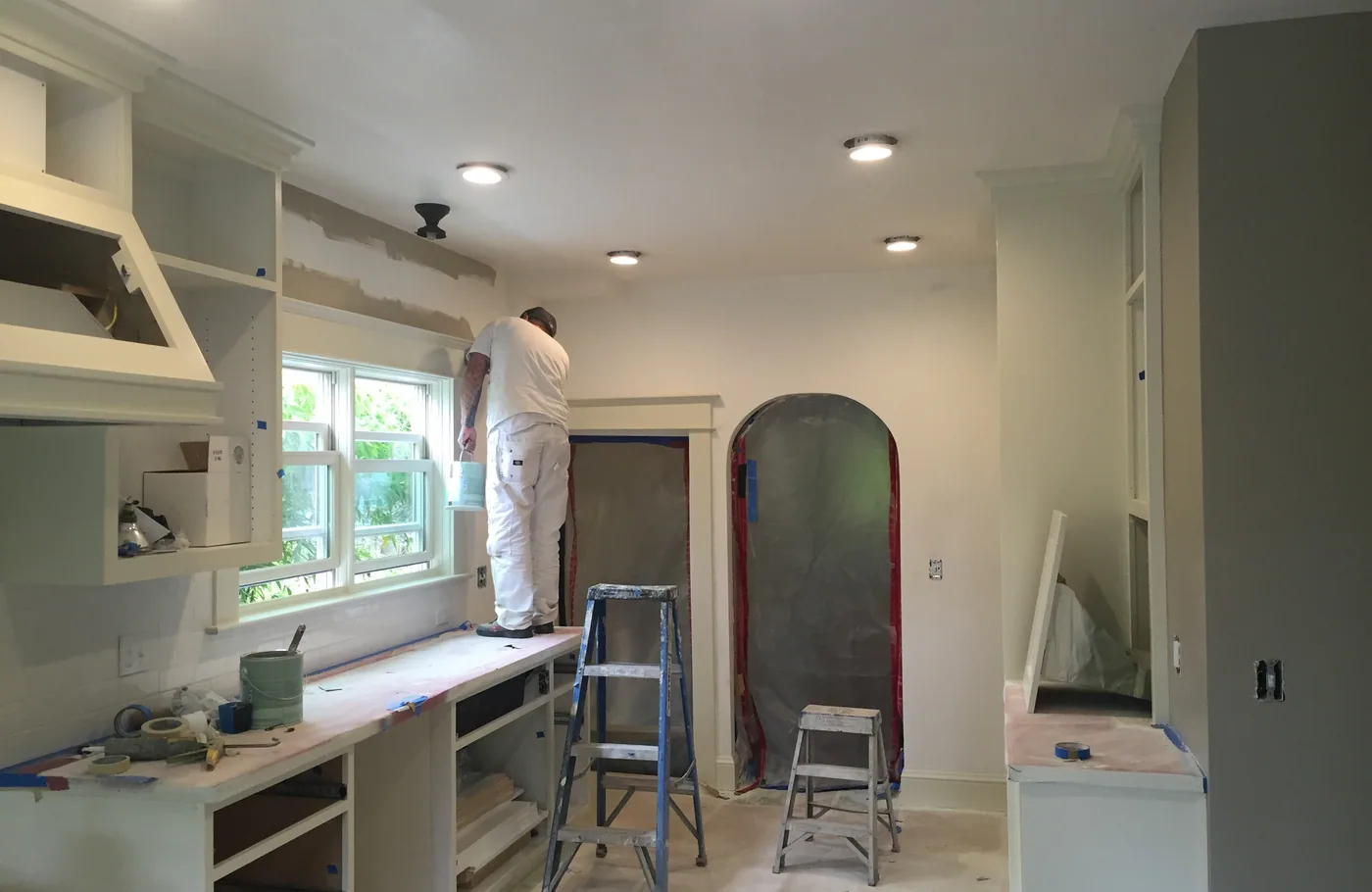 Painter working on built-in kitchen shelving