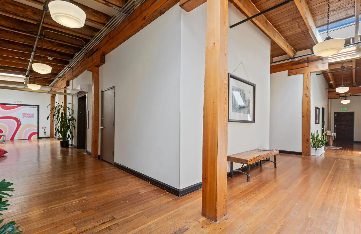 Commercial interior with white walls, timber posts and a painted ceiling