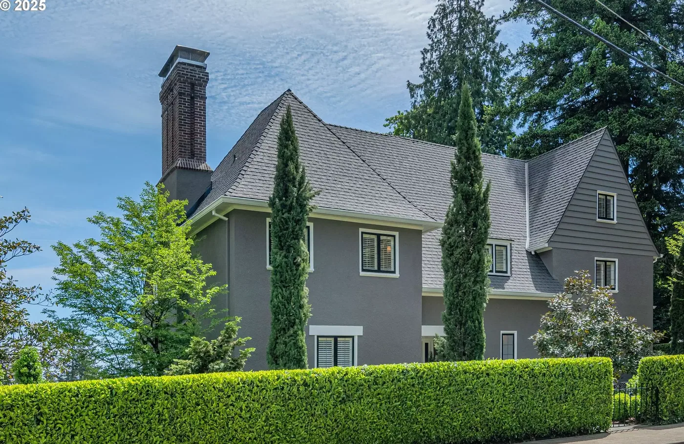 Tall grey home with a brick chimney