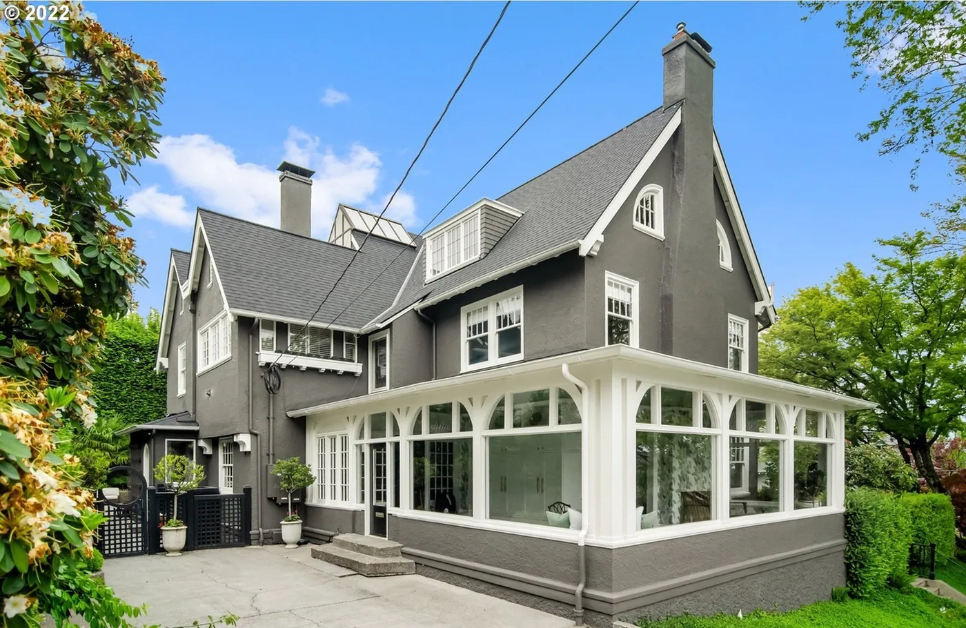 Dark grey home with a white sunroom