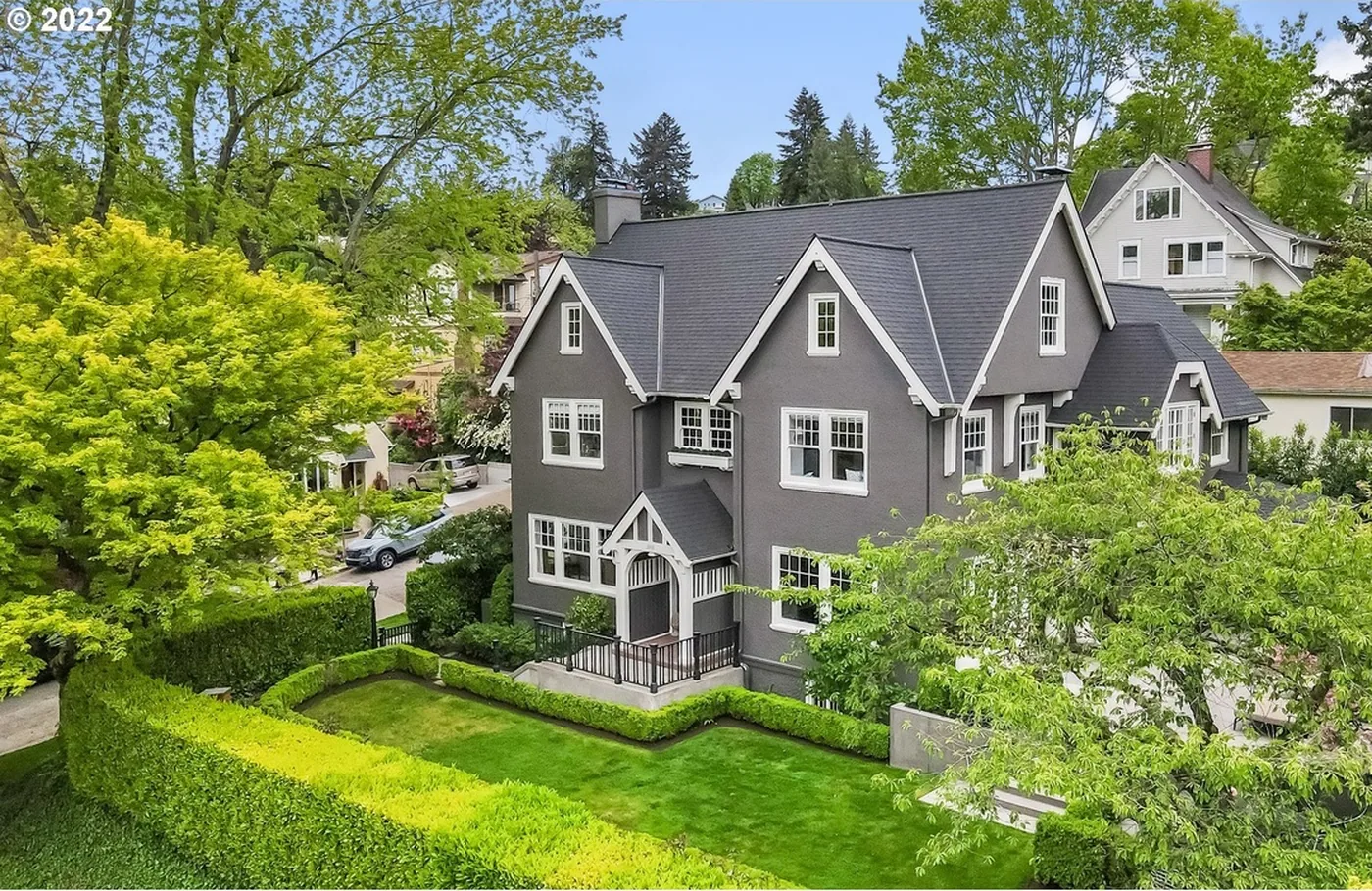 Dark grey home among mature trees