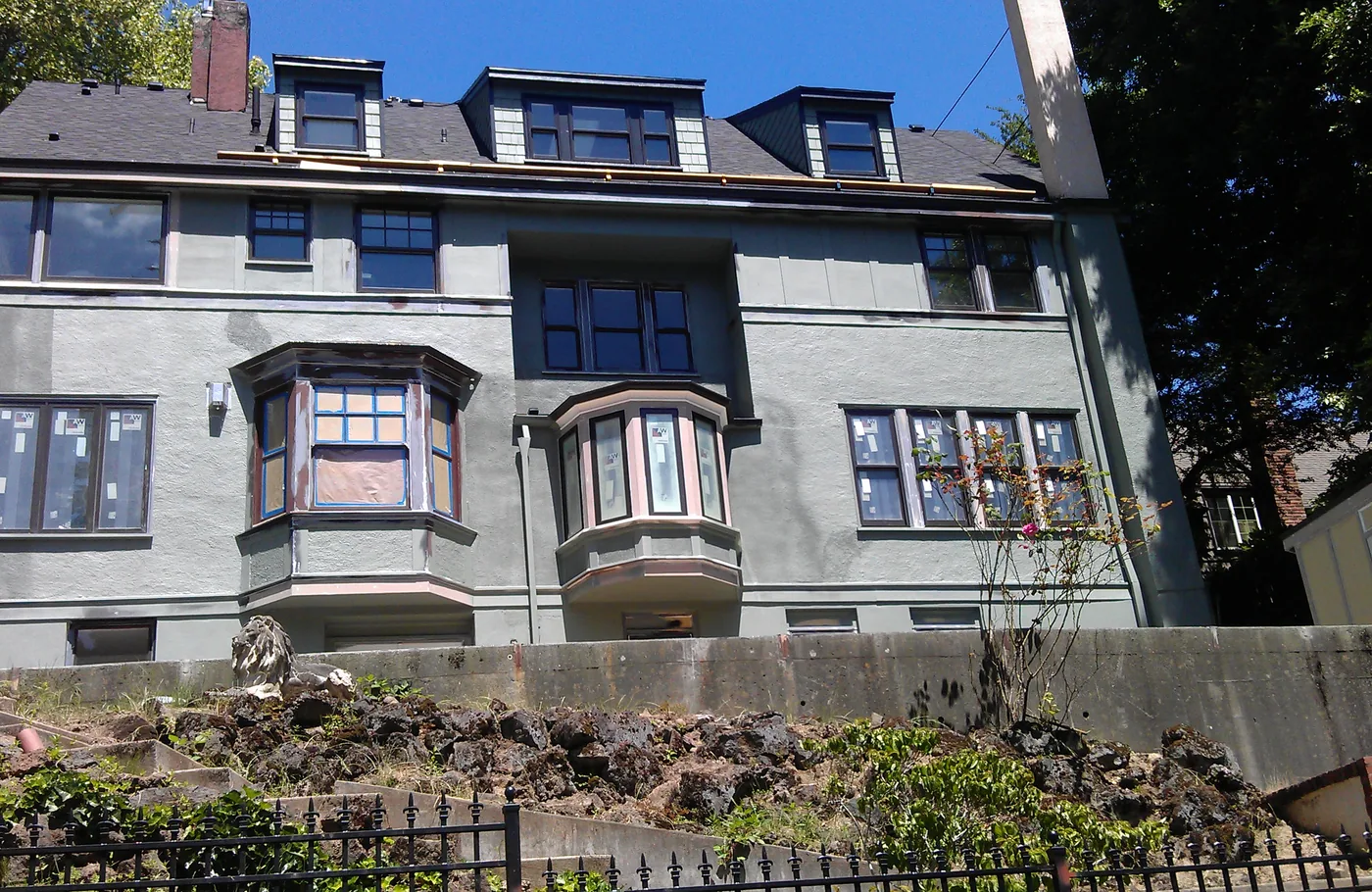 Grey stucco building with dark painted window trim