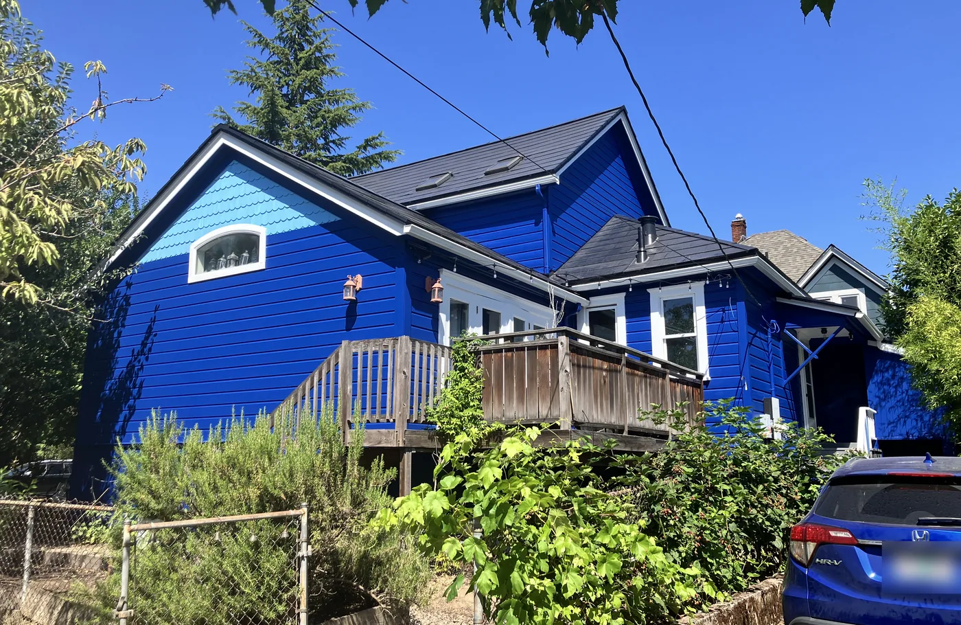 Bright blue Portland home with white trim and a wood deck