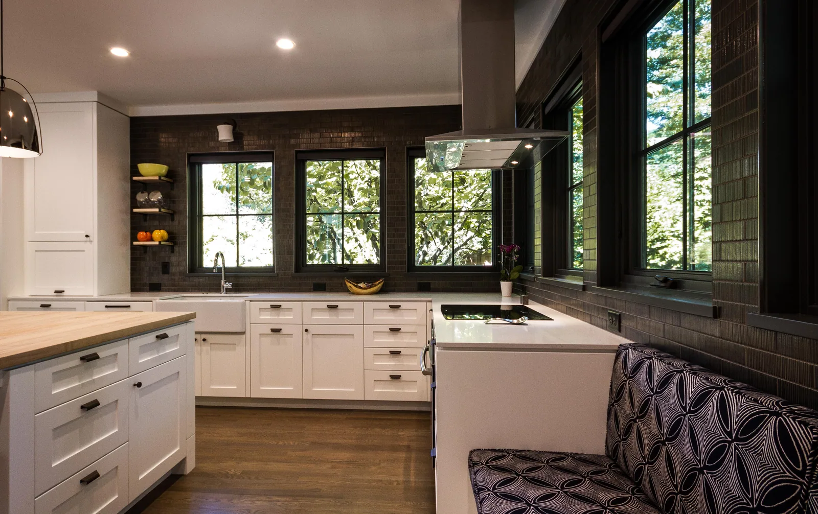 Kitchen and banquette with painted cabinetry and dark window frames