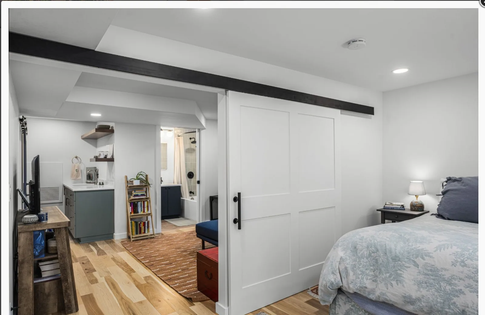 Bedroom with freshly painted walls, white trim and a sliding barn door