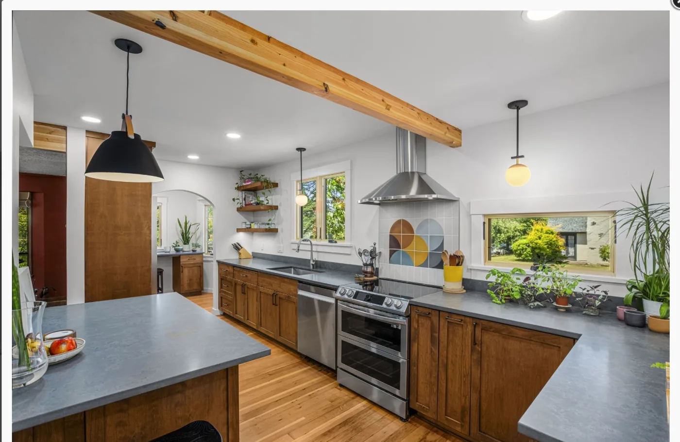 Kitchen with painted cabinets beneath exposed wood beams